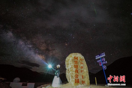圖為6月20日晚，游客“打卡”西藏阿里暗夜公園，天上是銀河與流星（右上角）。曹枝清 攝